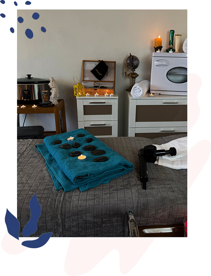 Уютный массажный кабинет с зажженными свечами и чистыми полотенцами.